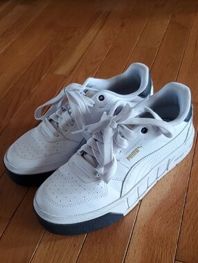 Puma White Sneakers with Gold Logo and Black Sole Accents
